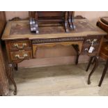 An Edwardian carved mahogany writing table with leather skiver