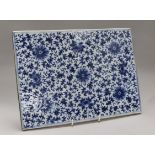 A Chinese blue and white large rectangular tile, decorated with an all-over pattern of flowers and