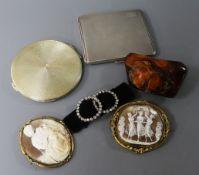 Two silver compacts, an amber pebble, two shell cameos and a pair of paste buckles