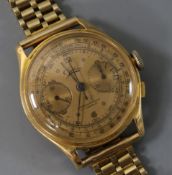 A gentleman's 18ct gold chronograph manual wind wrist watch on a 9ct gold bracelet.