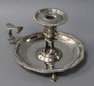 An early George III silver chamberstick, with shaped gadrooned rim, lacking snuffer, crested, London