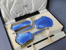 A cased George V Art Deco silver and enamel three piece dressing table set, Charles S. Green & Co,