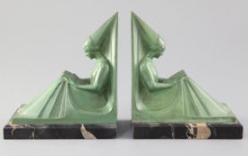 Max Le Verrier. A pair of green patinated spelter bookends, modelled as seated medieval maidens