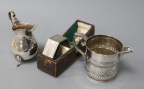 A Scottish Victorian silver cream jug, another silver cream jug and a cased napkin ring, the