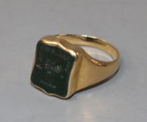 An early 20th century 18ct gold and bloodstone set signet ring, the matrix carved with crest and