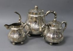 A Chinese 900 standard silver three piece tea set, c.1900, engraved with panels of bamboo and