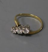An 18ct gold and three stone diamond crossover ring, size K.