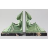 Max Le Verrier. A pair of green patinated spelter bookends, modelled as seated medieval maidens