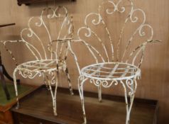 A pair of French wrought iron garden chairs