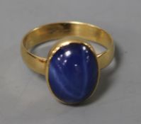 A cabochon star sapphire ring, yellow metal rubover setting and shank, size O.
