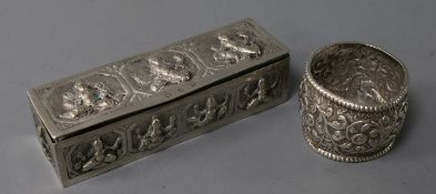 An Indian embossed white metal rectangular snuff? box and a white metal napkin ring.