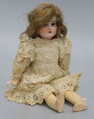 An Armand Marseille bisque head doll, with brown hair, go-to-sleep eyes, open mouth and jointed