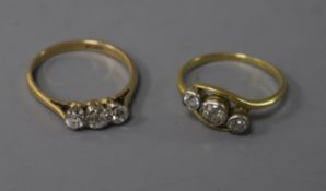 Two 18ct gold and three stone diamond rings including a crossover ring.