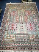 A Persian cream ground rug, woven with panels of stylised flowers 245cm x 173cm