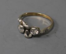 An early 20th century yellow metal and two stone diamond ribbon bow crossover ring, with diamond set