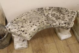 A curved stone garden bench W.110cm approx.