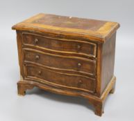 A miniature serpentine fronted chest of drawers width 25cm height 21cm depth 14cm