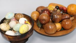 A group of egg shaped hardstone hand coolers and a group of turned and carved 'fruit'