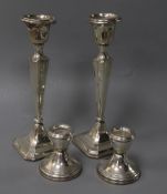 A pair of George V silver candlesticks and a pair of later silver dwarf candlesticks, tallest 20.