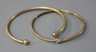A diamond set 9ct gold hinged bangle ( one stone missing) and a yellow metal bangle, gross 19.7