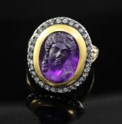A 19th century amethyst glass? oval cameo ring, with rose cut diamond set border, (adapted?), size