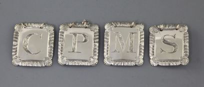 A set of four George III silver wine labels by John Reily, each with an engraved initial and