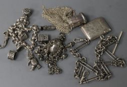 A silver charm bracelet, an Edwardian vesta on silver albert, a white metal purse and a