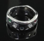 A modernist wavy design 18ct white gold, emerald, ruby, sapphire and baguette cut diamond gypsy
