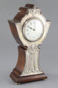 An early 20th century silver mounted mantel timepiece, Birmingham 1909, the shaped wooden case