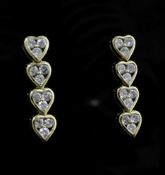 A pair of gold and diamond set drop earrings, modelled as a row of four hearts, each containing