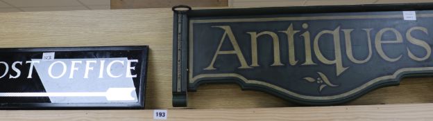 A glass "Post Office" sign and a wooden "Antiques"