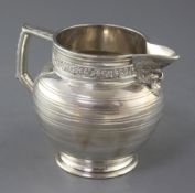 An Edwardian silver jug by Edward Barnard & Sons Ltd, decorated with vineous band and Bacchanalian