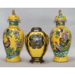 A pair of Carlton ware yellow ground vases and covers and a similar jar