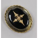 A Victorian yellow metal, black enamel and seed pear set oval mourning brooch, 44mm.