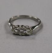 A modern 18ct white gold and three stone diamond ring, size L.