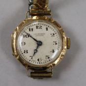 A lady's 9ct gold J.W. Benson manual wind wrist watch on a gold plated flexible bracelet.