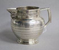 An Edwardian silver jug by Edward Barnard & Sons Ltd, decorated with vineous band and Bacchanalian