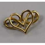 An 18ct gold scrolling heart brooch, with metal pin, 31mm.