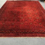 An Afghan red ground carpet 395cm x 300cm