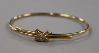 A modern Chaumet 18ct gold and diamond hinged bangle, with central "X" motif, gross 12.2 grams.