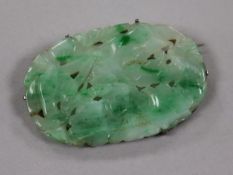 A Chinese white metal mounted carved jadeite brooch, 50mm.