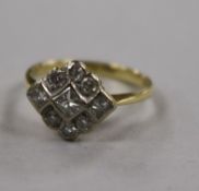 A yellow metal and diamond cluster ring, set with round and princess cut stones, size L.