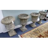 A set of four campana shaped reconstituted garden urns, on square plinths W. 45cm approx.