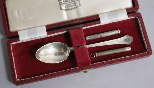 Two engine turned silver propelling toothpicks and a cased silver teaspoon.