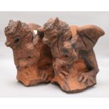 A pair of moulded terracotta griffins H.30cm x W.28cm