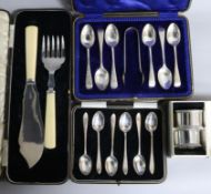 Two cased sets of six silver teaspoons, one with tongs, a cased set of silver fish servers and cased