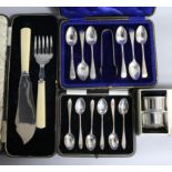 Two cased sets of six silver teaspoons, one with tongs, a cased set of silver fish servers and cased