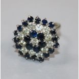 An 18ct white gold, sapphire and diamond cluster ring, size G.