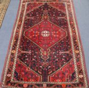 An Iranian red ground rug 188 x 120cm