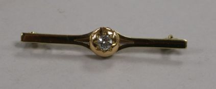 An early 20th century 15ct gold and solitaire diamond set bar brooch, 44mm.